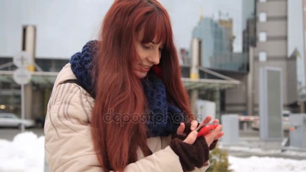 Mulher ruiva de cabelos vermelhos bonita usando aplicativo de tecnologia de telefone inteligente nas ruas da cidade vivendo estilo de vida feliz urbano — Vídeo de Stock