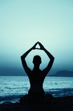 Gün batımında Yoga fitness egzersiz sahilde pratik genç sağlıklı kadın.
