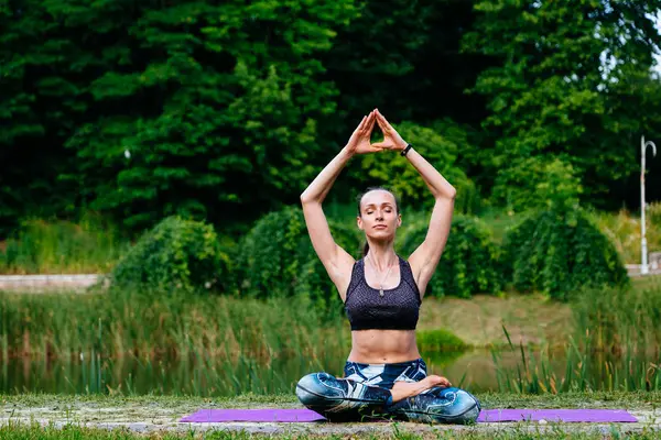 Yeşil park Yoga egzersiz yaparak genç kadın. Tonlu görüntü.