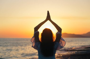 Genç kadın sahilde doğada sabah yoga uygulamak