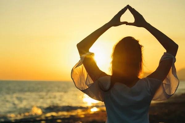 Genç kadın sahilde doğada sabah yoga uygulamak