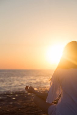 Genç kadın sahilde doğada sabah yoga uygulamak