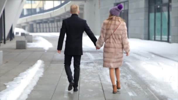 Mujer feliz y pareja de hombres caminando juntos en la ciudad tomados de la mano. Mujer con abrigo de piel . — Vídeo de stock