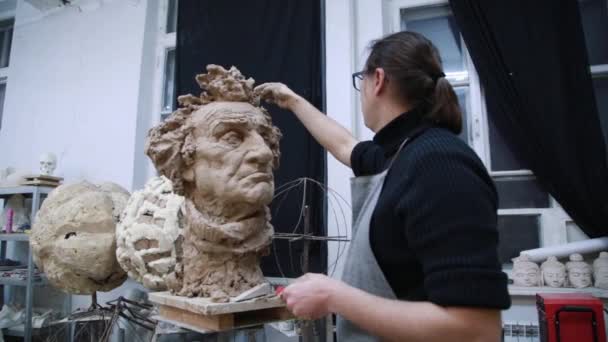 Scultore scultura modellante regolazione dettagli viso testa in argilla . — Video Stock