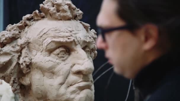 Scultore scultura modellante regolazione dettagli viso testa in argilla . — Video Stock