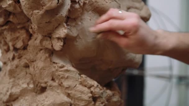 Sculptor modelling sculpture adjusting face details head made of clay. — Stock Video