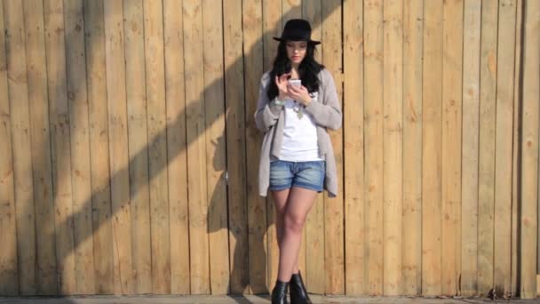 Mulher hipster bonita elegante mensagens de texto no smartphone na cidade — Vídeo de Stock