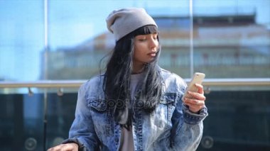 Güzel İspanyol latina kadın manifatura smartphone cep telefonu ile kentin moda.