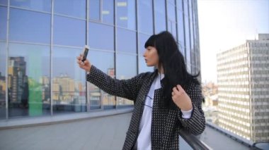 Güzel İspanyol latina kadın manifatura smartphone cep telefonu ile latte kahve içme kentin moda.