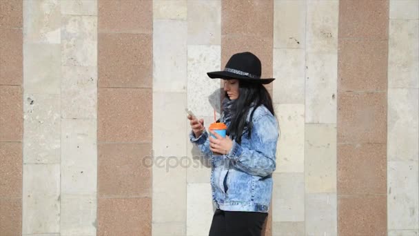 Moda hermosa mujer latina hispana mensajes de texto en el teléfono inteligente en la ciudad beber café con leche . — Vídeo de stock