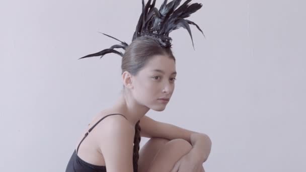 Young mixed race caucasian woman vogue portrait with feather mohawk accessory wearing black bodysuit. — Stock Video