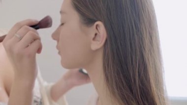 Profesyonel makyaj sanatçısı kozmetik koyarak. Modelleri yüzünde odaklanmak.