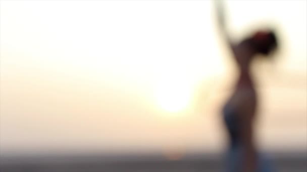 Actieve, vrolijke vrouw op het strand spelen met hoelahoep bij zonsopgang in mode jurk. — Stockvideo