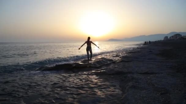 Jeune femme pratiquant le yoga sur la plage au coucher du soleil. — Video