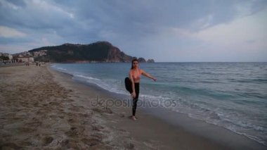 Akdeniz beach üzerinde gün batımında yoga yapmak spor kız