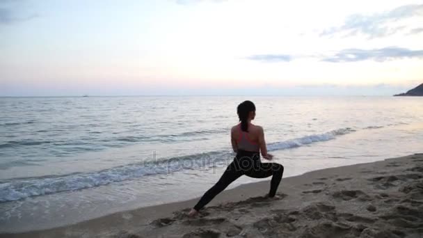 Deportiva haciendo yoga al atardecer en la playa del Mar Mediterráneo — Vídeos de Stock