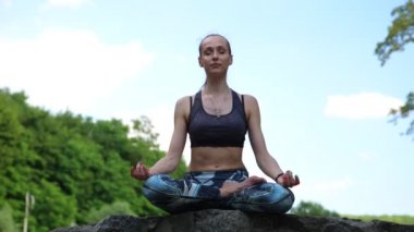 Yeşil Park 'ta yoga yapan genç bir kadın.