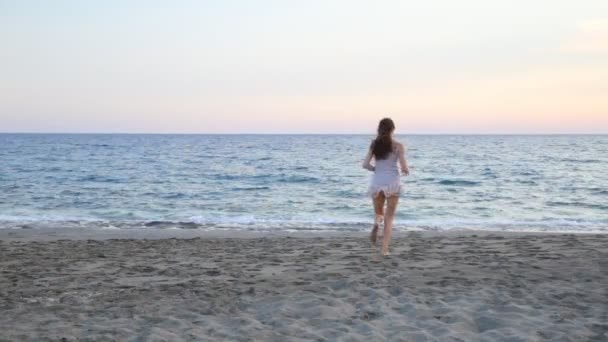 Красива жінка, що йде на райському пляжі на самоті під час заходу сонця . — стокове відео