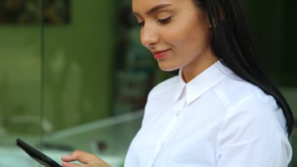 Latina Geschäftsfrau hält Tablet-PC in den Händen, trägt weiße Bluse. — Stockvideo