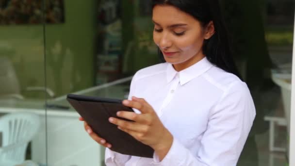 Latina Geschäftsfrau hält Tablet-PC in den Händen, trägt weiße Bluse. — Stockvideo