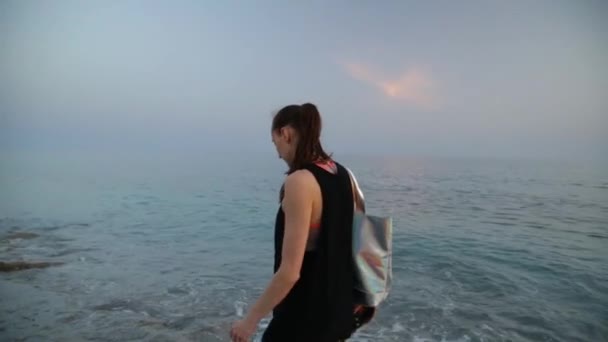 Jeune femme marchant sur une plage de sable fin de la mer Méditerranée au coucher du soleil — Video