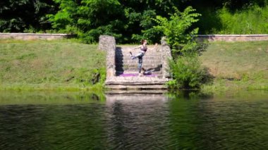 Yeşil Park 'ta yoga yapan genç bir kadın.