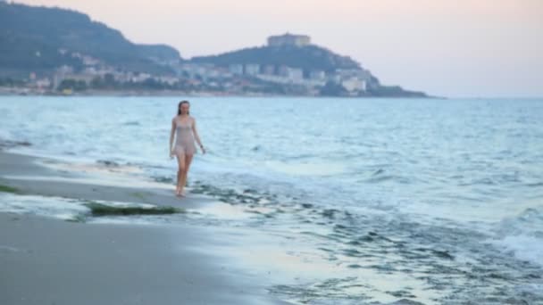 Mulher bonita andando na praia paradisíaca sozinha ao pôr do sol . — Vídeo de Stock