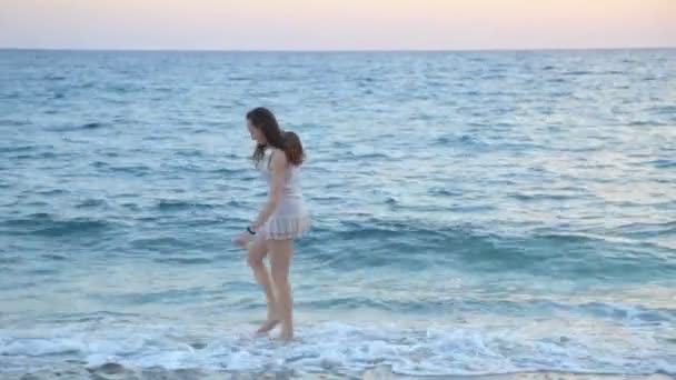 Belle femme marchant sur la plage paradisiaque seule au coucher du soleil . — Video