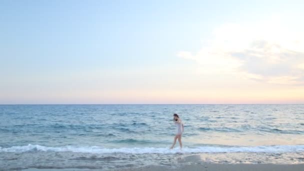 Piękna kobieta spaceru na plaży paradise sam o zachodzie słońca. — Wideo stockowe