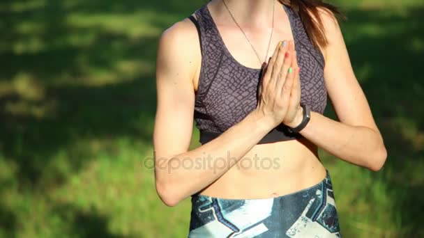 Primer plano de una joven haciendo ejercicio de yoga en un parque verde — Vídeos de Stock