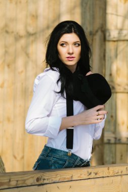 Kameraya ahşap arka plan üzerinde arayan genç mutlu çiftçi hipster kadın portresi.