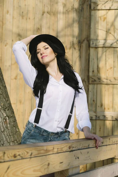 Ritratto di giovane donna hipster contadina felice che guarda la macchina fotografica su sfondo di legno . — Foto Stock