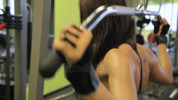 Ung kvinna som arbetar hennes kropp på gymmet. Att göra träning träning inomhus. — Stockvideo