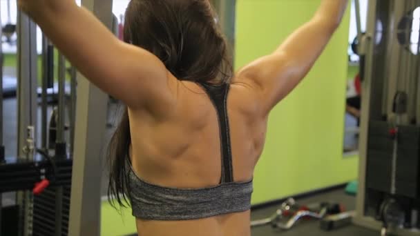 Mujer joven trabajando su cuerpo en el gimnasio. Hacer ejercicio en interiores . — Vídeo de stock