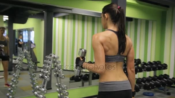 Donna di razza mista adulta che si allena con pesi in palestra . — Video Stock