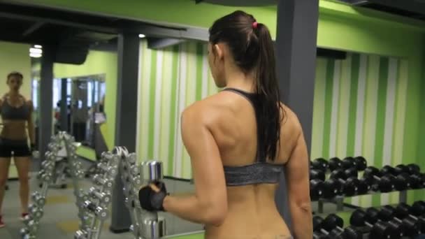 Donna di razza mista adulta che si allena con pesi in palestra . — Video Stock