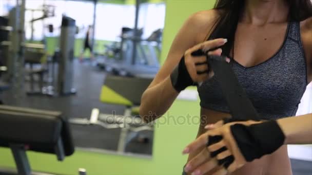 Bella modella che indossa i guanti in palestra pronta per l'allenamento. Forza in forma corpo . — Video Stock