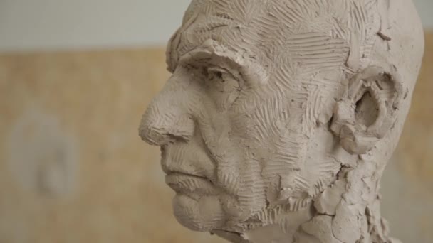 Sculptor modelling sculpture adjusting face details head made of clay. — Stock Video