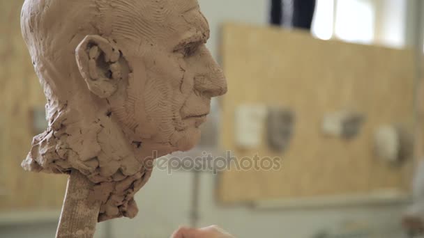 Scultore scultura modellante regolazione dettagli viso testa in argilla . — Video Stock