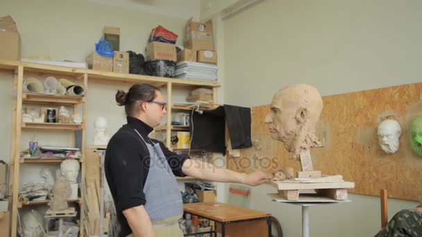 Scultore scultura modellante regolazione dettagli viso testa in argilla . — Video Stock