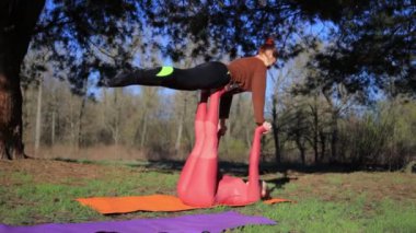 Gün batımında acroyoga parkta pratik kadınlar Çift