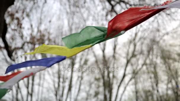 Gros plan Drapeaux de prière bouddhistes tibétains soufflant dans le vent . — Video