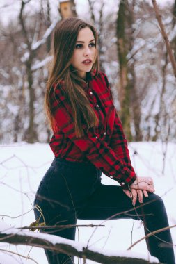 Bir soğuk kış kar Orman ağaçları arka plan üzerinde kırmızı Kareli gömlekli giysili kadın.