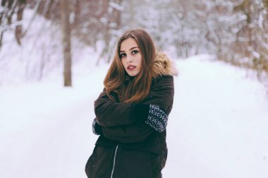 Kadın sıcak soğuk kış kar ormandaki ağaçlar üzerinde arka plan ile giydirilmiş.