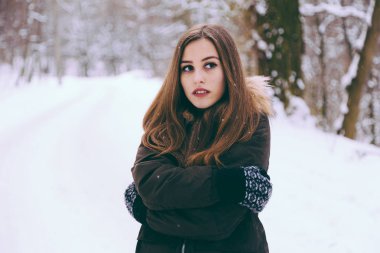 Kadın sıcak soğuk kış kar ormandaki ağaçlar üzerinde arka plan ile giydirilmiş.