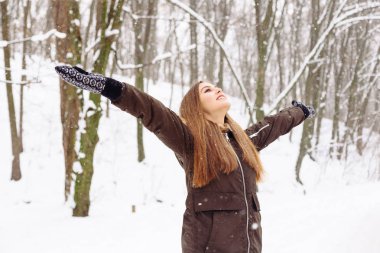 Kadın sıcak soğuk kış kar ormandaki ağaçlar üzerinde arka plan ile giydirilmiş.