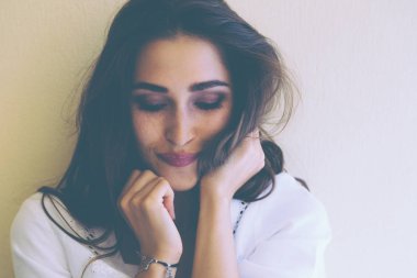 Güzel kadın model mükemmel gülümseme ve sağlıklı dalgalı saç ile gülümseyen izole sarı duvara mutlu. Mutluluk kavramı.