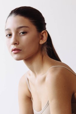 Güzellik Spa kadın mükemmel cilt portre ile. Güzel esmer kız açık el avuç metin için boş kopya alanı gösterilen. Bir ürün öneriyor. Bej renkli arka plan