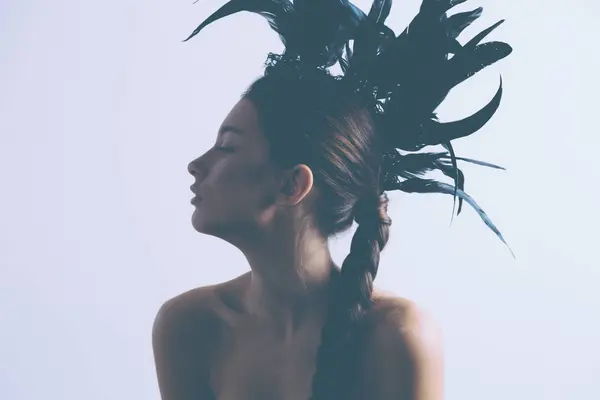 Νέοι σέξι μικτή φυλή καυκάσιος γυναίκα vogue πορτρέτο με φτερό mohawk αξεσουάρ φορώντας μαύρο κορμάκι. — Φωτογραφία Αρχείου