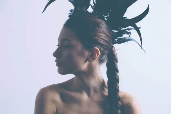 Joven sexy raza mixta caucásica mujer vogue retrato con pluma mohawk accesorio usando negro body . — Foto de Stock